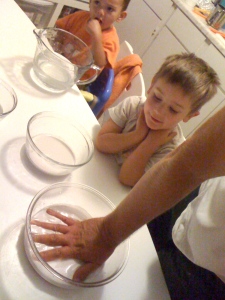 Dad casts hand in plaster while child watches.